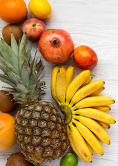 Set of various tropical fruits on a white wooden background, from above. Flat lay, overhead, top view.