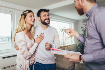 Real Estate agent shows interior to young couple