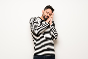 handsome man with striped shirt making sleep gesture in dorable expression