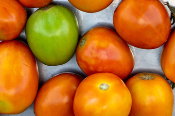 The fresh tomatoes on a tray for sale in the bazaar.