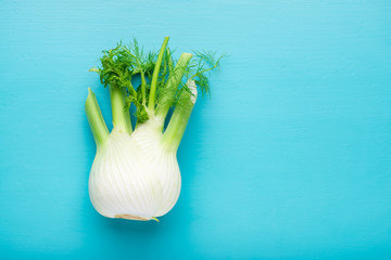 Fresh fennel bulb over blue wooden background, top view