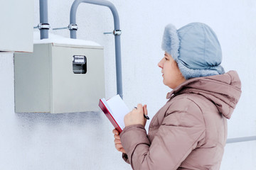 winter, snow, cold. the girl, the engineer, the worker records the readings of the sensors and...