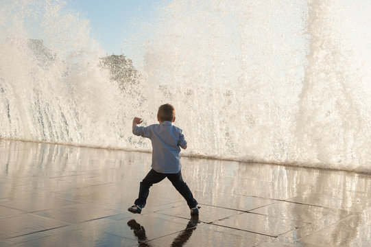 one little kid escaping frome huge wave on sea shore in city during storm weather