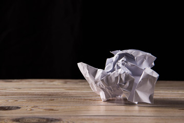 Crumpled white paper on a wooden table - 245557576