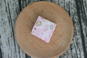 Nougat rose sur une assiette en bois