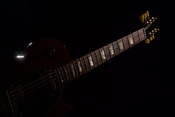 Obraz na płótnie Canvas red electric guitar closeup on black background
