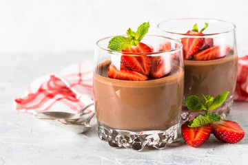 Chocolate panna cotta sweet dessert with strawberries in glass.