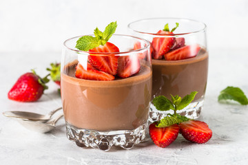 Chocolate panna cotta sweet dessert with strawberries in glass.