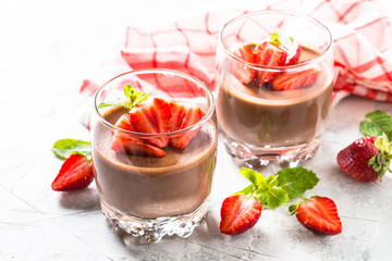 Chocolate panna cotta sweet dessert with strawberries in glass.