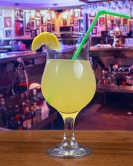 Mai Tai cocktail in tulip glass with lemon slice and straw
