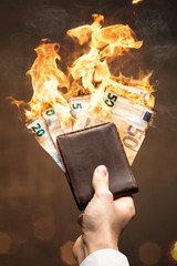 Brennende Euro Scheine in einer Geldbörse