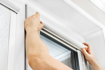 Man installing cassette roller blinds on windows