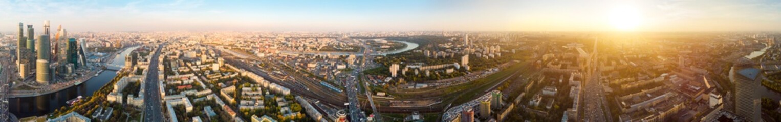 panorama high-rise buildings and transport of metropolis, traffic and blurry lights of cars on multi-lane highways and road junction at sunset in Moscow.