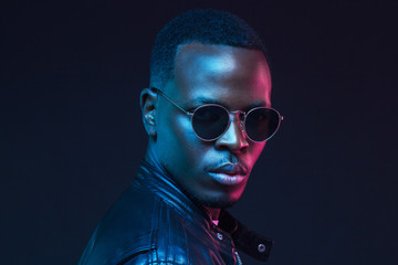 Afrikanisches Männermodel-Porträt mit trendiger Sonnenbrille und Lederjacke © Damir Khabirov