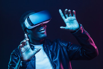 Young african man having virtual reality experience using vr headset