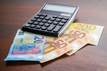Stack of European cash money next to a electronic calculator 
