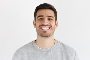 Obraz premium Young handsome man smiling happily and friendly at camera, isolated on gray background