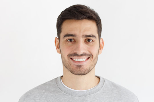 Close-up daylight portrait of young smiling handsome man isolated on gray background