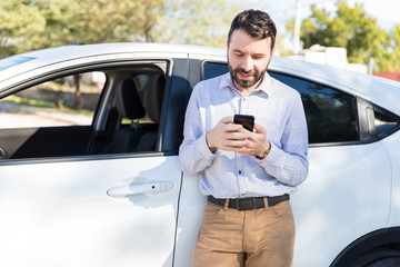 Owner Using Mobile Phone Against White Car