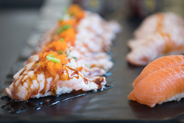 Row of burned salmon with sauce