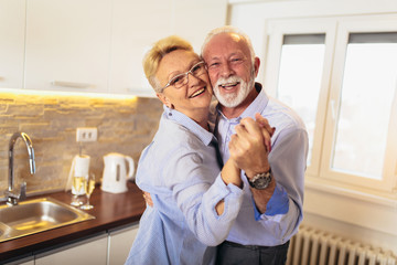 Senior couple dancing together in kitchen