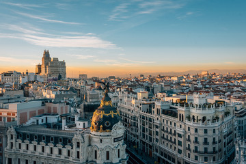 View of the Metropolis Building and Gran Via from the Circulo de Bellas Artes rooftop at sunset, in Madrid, Spain