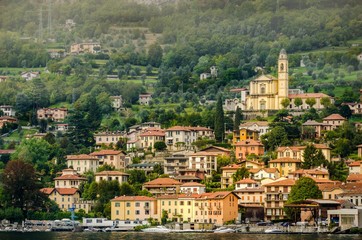 Fototapeta premium View of village in forest in Lake Como from ferry at sunset, chu