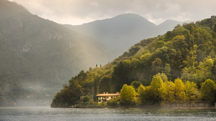 Fairy tale view of morning light to mystery in forest in mist, Lake Como, Italy