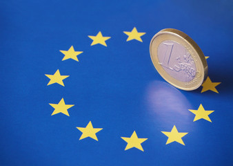 Closeup of a 1 euro coin on top of the European flag