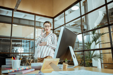 Busy pregnant creative interior designer calling her client