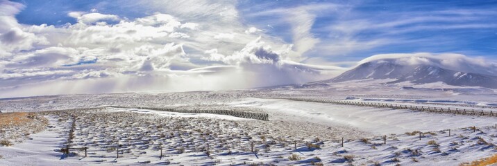 Obraz premium Wyoming countryside panoramic views during a blizzard with mountain with snow covered with overcast grey cloudy sky. Wyoming, United States.
