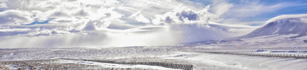 Wyoming countryside panoramic views during a blizzard with mountain with snow covered with overcast grey cloudy sky. Wyoming, United States.