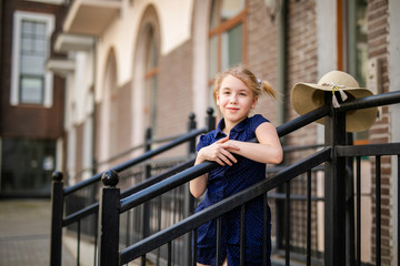 Portrait of blonde girl 10 years old playing among beautiful old houses