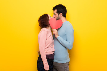 Couple in valentine day holding a heart symbol and kissing