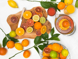 beautiful still life with citrus fruits on white paper background and wooden board and knife