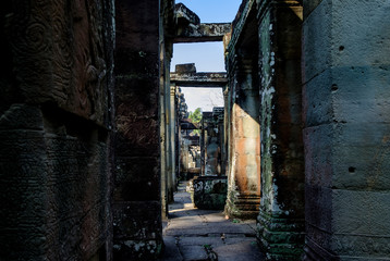 Narrow corridors in ruins of old ancient Angkor temple in Cambodia. Abstract architectural background.