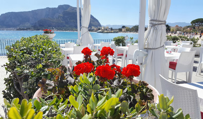 Cafe with view of the Coast on Mondello in Palermo, Sicily, Italy. Tables in the restaurant on the sea background.