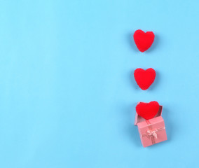 Fototapeta premium beautiful red hearts in gift box on pastel blue background. Valentines day concept flat lay
