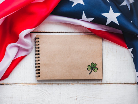 Notepad with congratulatory inscription and american star striped flag. St.Patrick's Day. Beautiful card. Close-up, wooden surface. Congratulations for loved ones, relatives, friends and colleagues