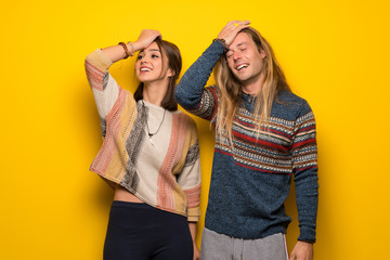 Hippie couple over yellow background has just realized something and has intending the solution