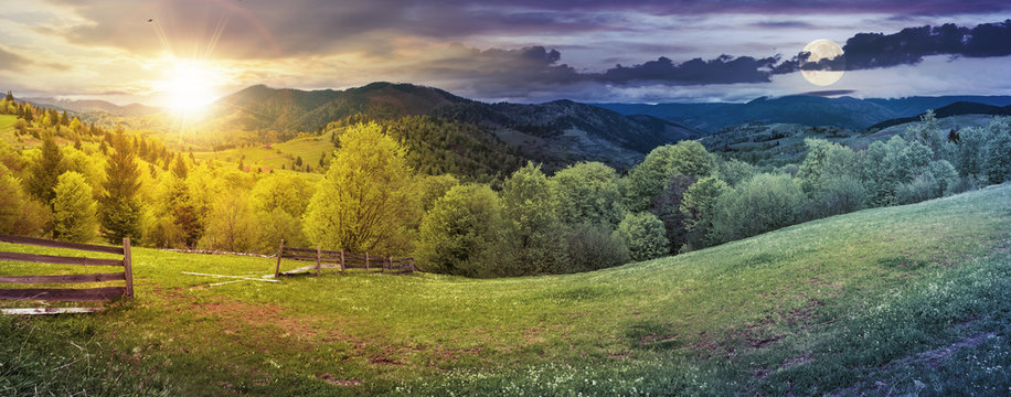 day and night time change above panorama of mountainous countryside in springtime. beautiful highland landscape with sun and moon. wooden fence on the grassy field. row of trees along the hill