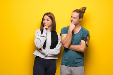 Group of athletes over yellow background looking to the side with the hand on the chin
