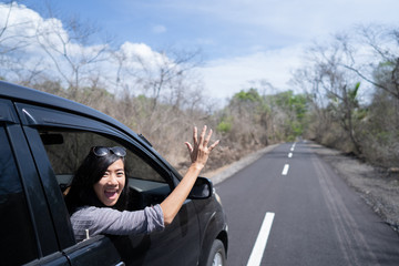 woman enjoying her trip going on vacation by car