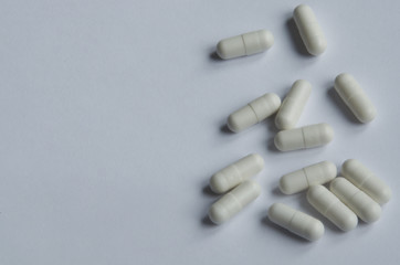 Medical and pharmacy theme. White pills on white background.