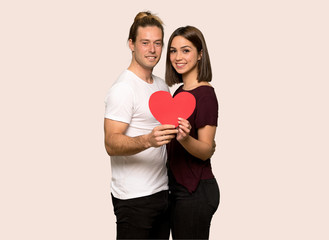 Fototapeta na wymiar Couple in valentine day holding a heart symbol over isolated background