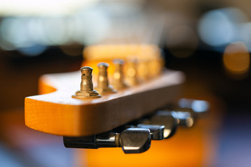 close up of the peg on the fingerboard of an blurred electric guitar