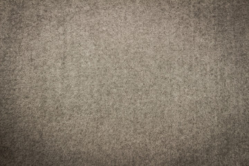 Gray blanket texture for background with black vignette. Close-up of natural warm wool coverlet, wrap, coverlid. Original pattern