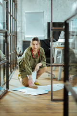 Pregnant woman after dropping documents on the floor