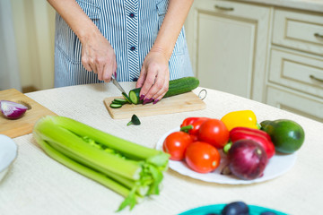 woman's hands cutting salad in the kitchen of fresh vegetables
