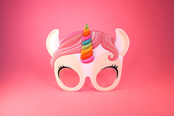 Unicorn sunglasses isolated on a pastel pink background. Minimal summer concept.
